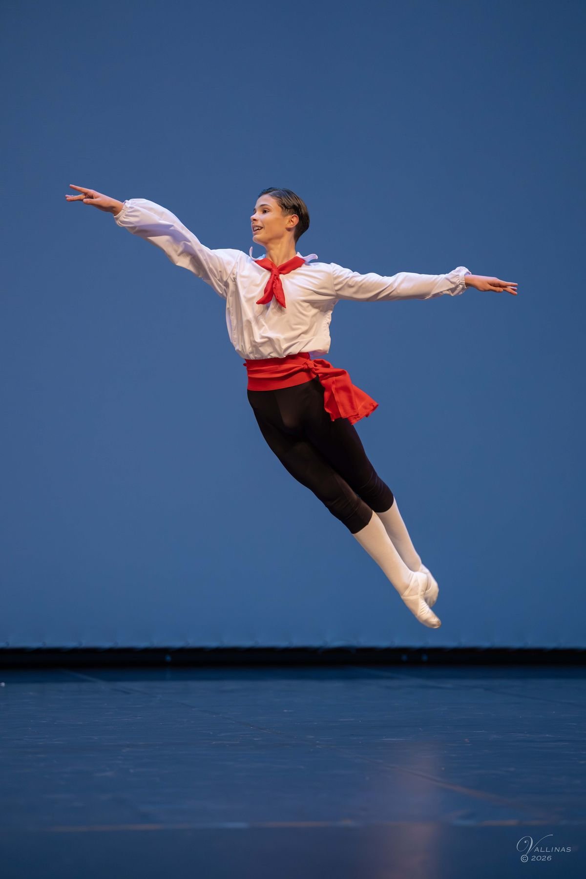 Bailarín de bolera con faja roja en un salto
