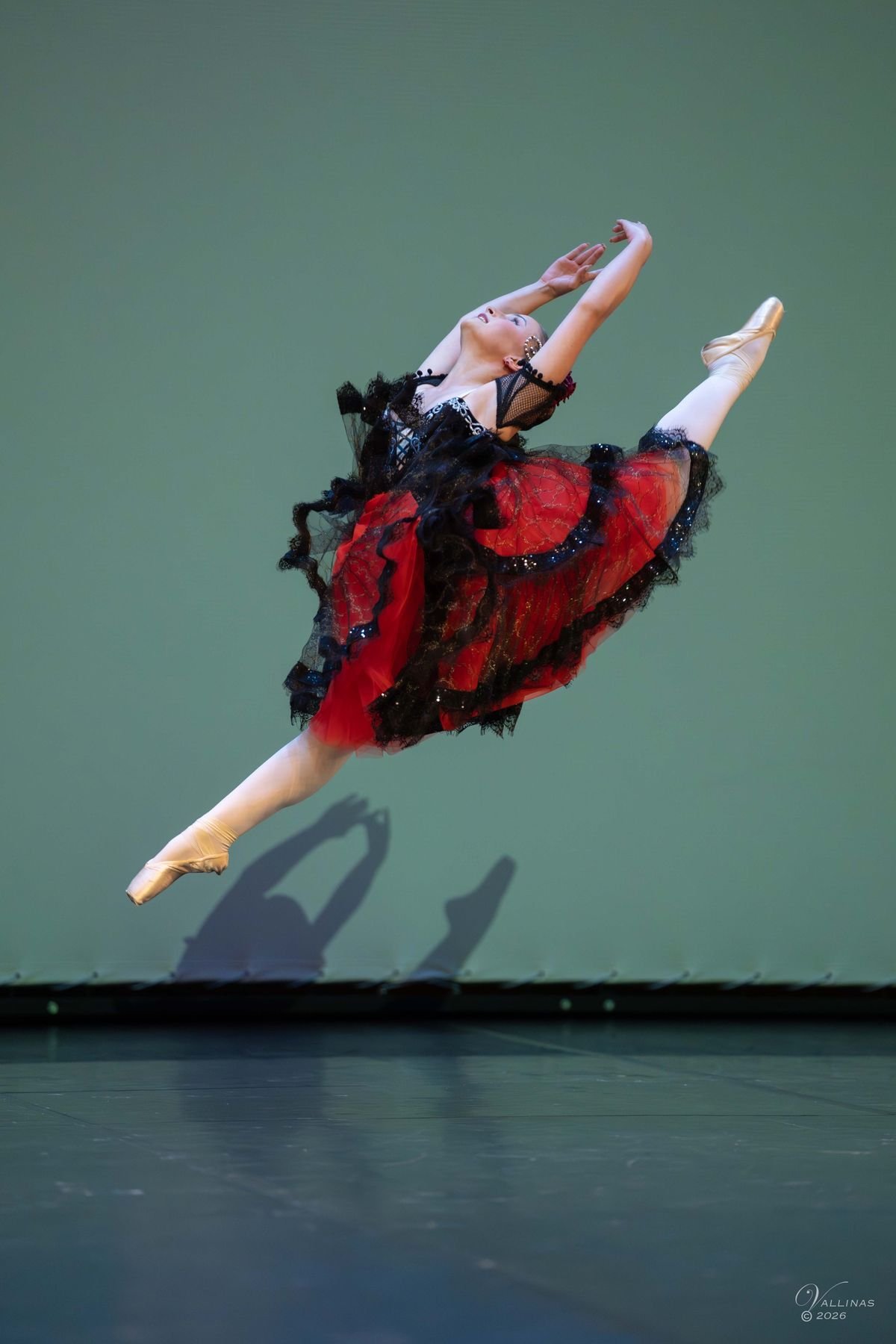 Bailarina de bolera con falda roja y negra en un gran salto