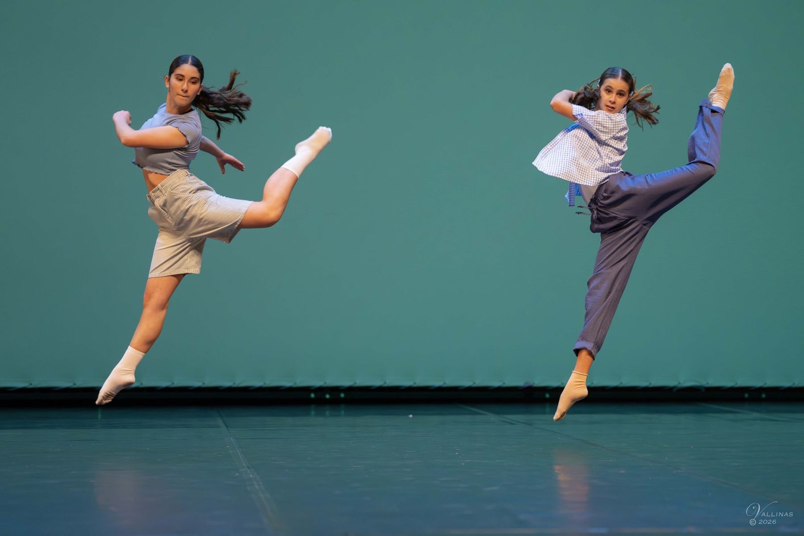 Dos bailarinas saltando a la vez sobre fondo verde