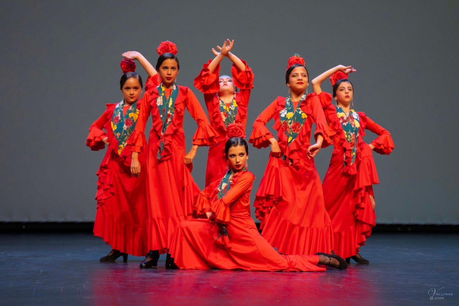 Grupo infantil de flamenco con vestidos rojos posando en escena