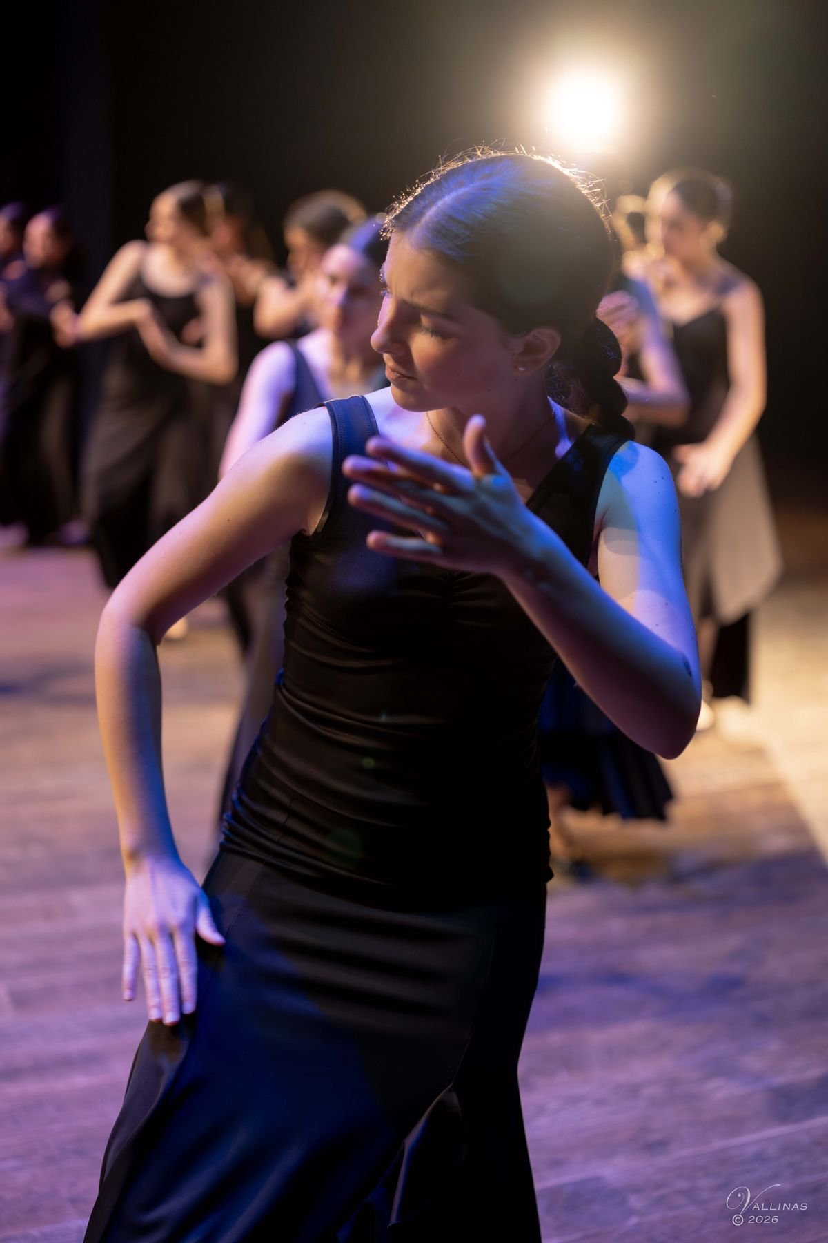 Alumna de flamenco sonriendo con el brazo levantado durante la clase